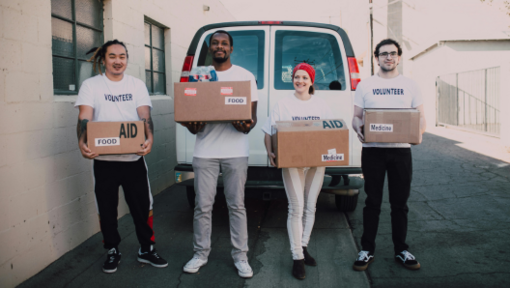 a group of volunteers holding boxes of supplies